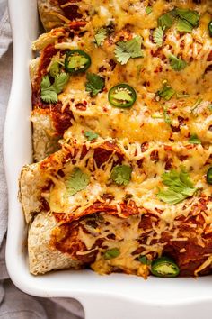 a white casserole dish filled with chicken, cheese and jalapenos