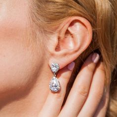 a close up of a woman's ear with two diamond earrings on her left side