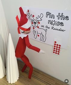 the elf is pointing to his reindeer on the wall