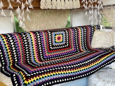 a crocheted blanket is sitting on a bench