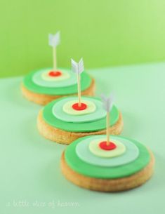 three cookies decorated with green and red icing on top of each other in the shape of arrows