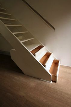 an empty staircase with drawers underneath it