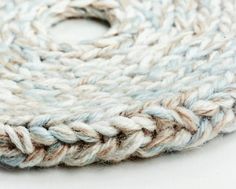 a close up view of a white and blue yarn spool on a white surface