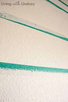 the wall is painted white and green with some blue lines on it that are going up