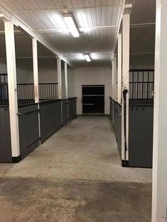 an empty horse barn with stalls and doors