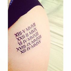 a tattoo with roman numerals on the back of a woman's leg