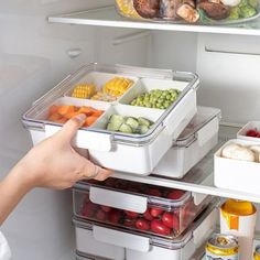 the refrigerator door is open and there are many food items in containers on the shelves