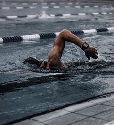 a man is swimming in the water with his hand on his hip and arm extended