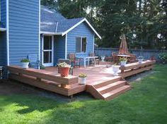 a wooden deck in front of a blue house