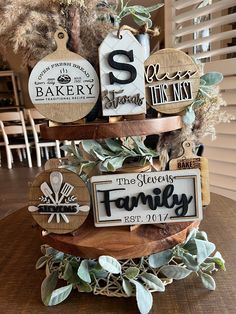 a three tiered cake decorated with wooden signs and greenery