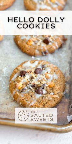 chocolate chip cookies with white icing on a baking sheet and the words hello dolly cookies above them