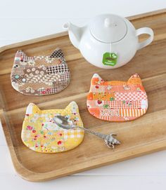 four bibs and a teapot on a tray