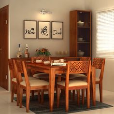 a dining room table and chairs with pictures on the wall