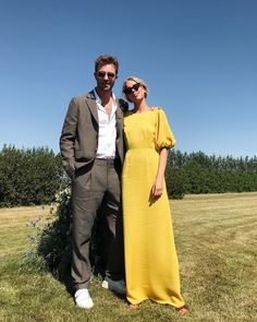 a man and woman standing next to each other in a field