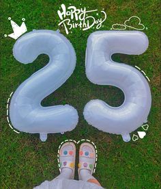 someone is standing in the grass with their feet on an inflatable number 25