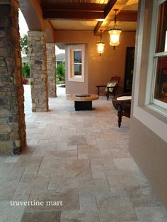 an outdoor living area with stone flooring and lighting