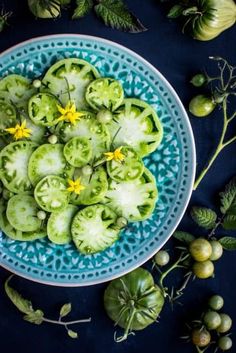 a blue plate topped with cucumbers and flowers