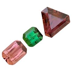 three different colored diamonds on a white background, one is green and the other is pink