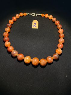 The beautiful orange color carnelian beads necklace from Himalaya Nepal This beads were used in prayer malas and used as jewelry and amulets in ancient times very smooth and shinny surface of this beads because of passage of time and usage of this beads in prayers mala and in necklace The age of this beads are more than 1000 years small size gold color brass beads are used as spacers in the necklace we provide fast and free shipping service to our customers by which can get the items by maximum Traditional Orange Necklace With Natural Stones, Carnelian Single Strand Necklace For Healing, Traditional Orange Gemstone Bead Necklaces, Single Strand Carnelian Necklace In Amber, Single Strand Carnelian Necklace For Healing, Orange Carnelian Polished Beads Necklace, Traditional Orange Jewelry For Healing, Amber Carnelian Single Strand Necklace, Traditional Orange Healing Jewelry