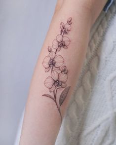 a woman's arm with a flower tattoo on the left side of her arm