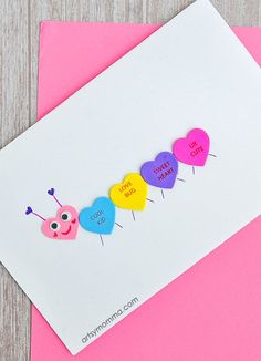 a card with the word love is spelled on it and three hearts in different colors