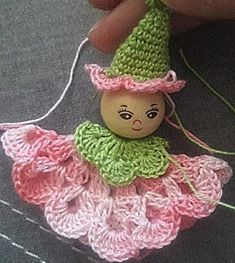 a crocheted doll with a green hat and pink dress