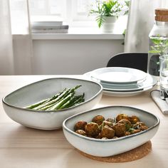 there are three bowls on the table with asparagus and meatballs in them