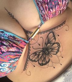 a woman's stomach with a butterfly tattoo on her belly and the bottom part of her stomach