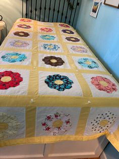 a quilted bedspread with flowers on it in a room next to stairs