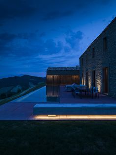 an outdoor dining area lit up at night with the lights on and in front of it