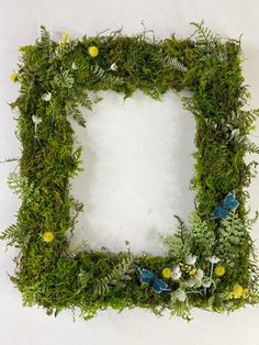 a square frame made out of moss and flowers