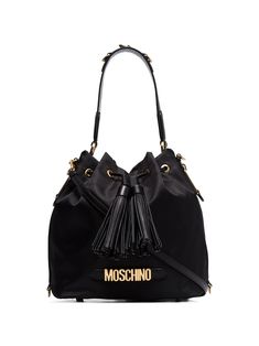 This Moschino logo plaque bucket bag boasts a technical construction with tonal leather trims. Fully lined, it’s characterised by its slouched shape and signature gold-tone logo lettering. \ Black Detachable and adjustable leather shoulder strap Single leather top handle Drawstring closure with tassel detail Two zip fastening side pockets Logo plaque to the front Brushed gold-tone hardware Metal feet at the base One main compartment with internal slip pocketCrafted in Italy Pocket Craft, Moschino Bags, Moschino Logo, Drawstring Bucket Bag, Pretty Bags, Cute Bags, Black Logo, Fun Bags, Bag Straps