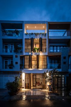 an apartment building lit up at night with lights on the windows and balconies