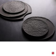 two plates sitting on top of a table next to each other, one is made out of concrete