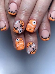 an orange and white nail with halloween decorations on it