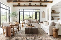 a living room filled with lots of furniture next to a large open floor plan window