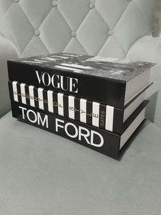 two black and white books sitting on top of each other in front of a couch