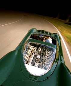 an overhead view of a green sports car driving down the road with its engine compartment open