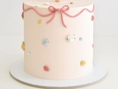 there is a pink cake with flowers on the top and a wooden stick sticking out of it