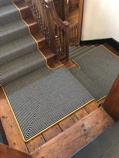 a stair mat is on the floor in front of a wooden banister and stairs