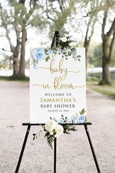 a welcome sign with greenery and flowers is displayed in the middle of a path