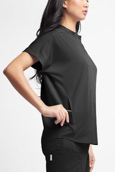 So many graceful details! This top looks like a button-up, but pops easily over your head. Ruching softens the silhouette front and back. Dolman sleeves feel so comfortable. WhisperLite may be your coolest-feeling scrubs ever. Feather light poplin with wicking and 4-way stretch that also repels lint, fur, and hair. And with extra chic, feminine styling, they look cool too. • Oversized fit • V-neck with banded collar • Total of 3 pockets • 2 large onseam front pockets • 1 cell pocket in right poc Scrub Style, Feather Light, Scrub Tops, Dolman Sleeve, Look Cool, Stand Collar, Polyester Spandex, Scrubs, Fashion Forward