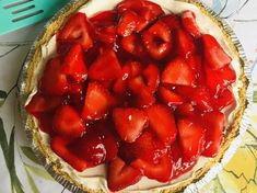 there is a pie with strawberries on it and a fork next to the pie