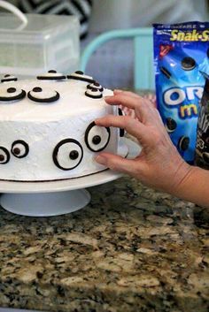 a cake with googly eyes on it being held up by someone's hand