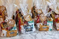 several bags filled with different types of candy and candies on a marble counter top