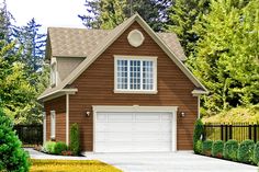 a house with a driveway and trees in the background