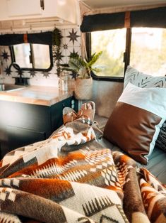 the interior of a camper with pillows and blankets