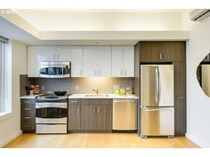 a kitchen with stainless steel appliances and wood floors