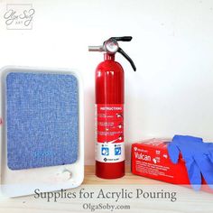 a red fire extinguisher next to a blue box and gloves on a table