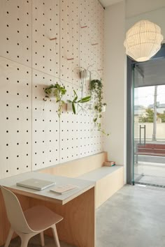 a desk with a laptop on it in front of a wall mounted planter and light fixture